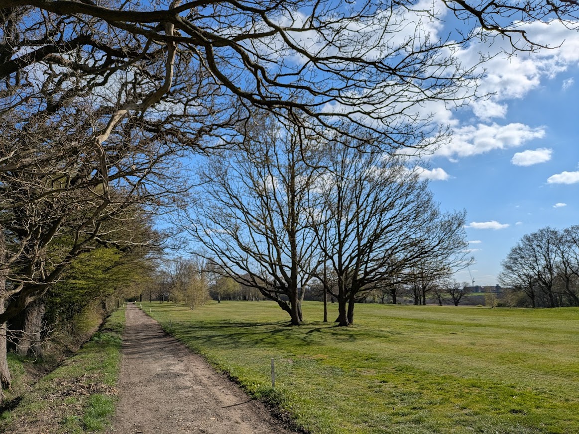Crews Hill Golf Course, showing open grassland, mature trees and a public path.